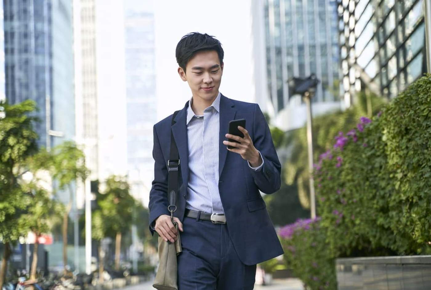 Man walking past modern buildings equipped with smart building automation systems