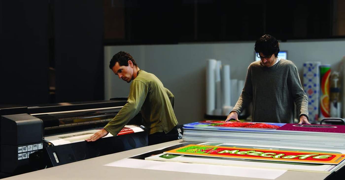 Print shop professionals using new equipment to print out customer orders