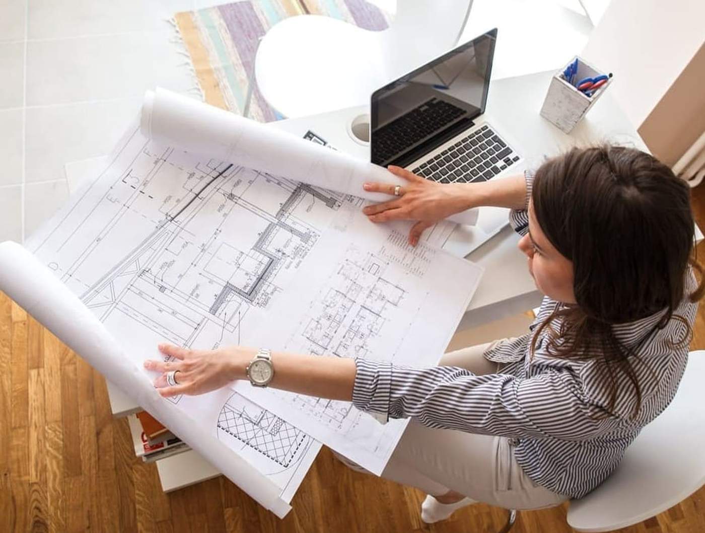 Architect having both small and large blueprints after working to streamline print management